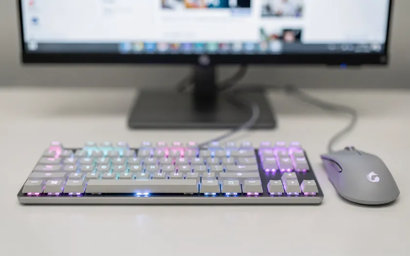 Gaming-mus och tangentbord på vitt skrivbord med RGB-belysning