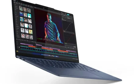 Vit Lenovo Yoga Slim 7x Gen 11 laptop med öppen skärm som visar abstrakt bakgrund i blått, orange och rött. Tangentbordet är vita tangenter på vit grund.