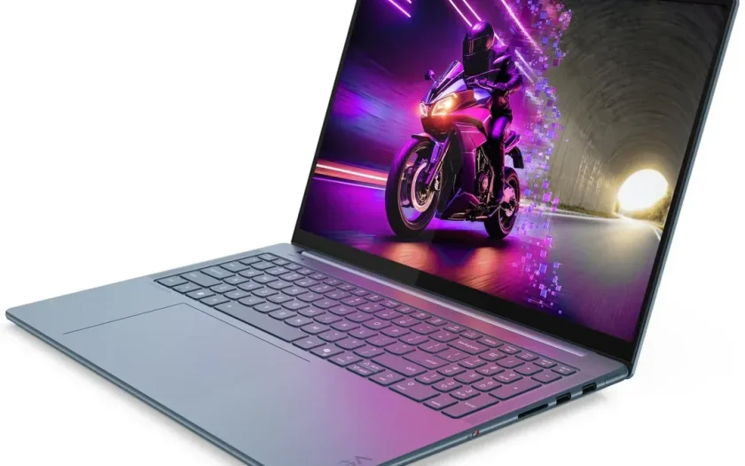 Lenovo-laptop med grått lock och rosa belyst tangentbord, visad från sidan i öppet läge.